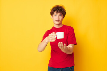 guy with red curly hair white mug in the hands of a drink yellow background unaltered