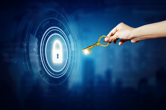 Hand holds golden key to open a virtual padlock