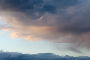 Naklejka na ściany i meble Dark volume clouds in the sky. Sunset. The last rays of the sun. Texture.