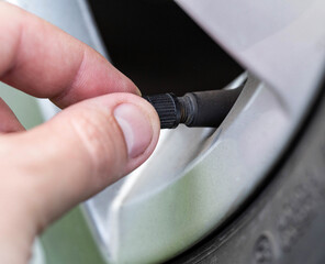 A man spins a wheel valve in a car, close-up