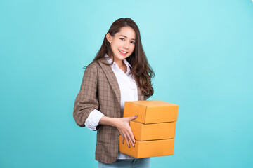 Delivery, relocation and unpacking. Smiling young woman holding cardboard box isolated on green background.