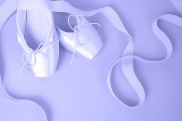 Romantic background. Satin ballet pointe shoes with ribbons in trending color 2022. Place for text. View from above.