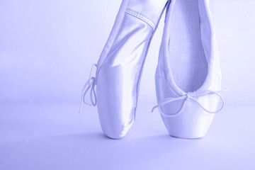 Satin ballet pointe shoes with ribbons in trending color 2022. Place for text. Side view.