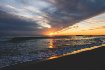 Naklejka na ściany i meble 美しい夕日の光に包まれた海の景色