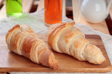 Close-up view of Homemade croissants on a wooden board. Soft focus.