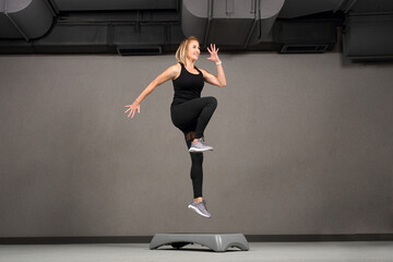 
Stepp jump, step fitness.
Sports training, a young attractive woman is exercising in a class at a fitness club