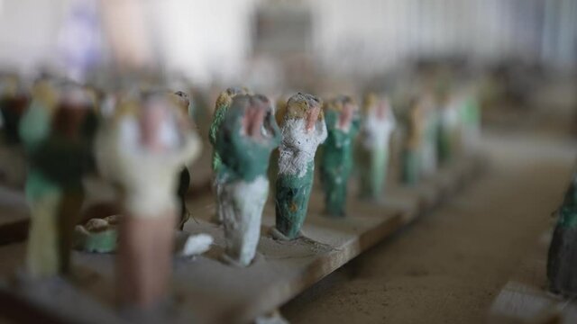 Close-up pan across tiny prisoner of war clay sculptures