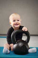Child at the gym. A small child with a weight for strength training.