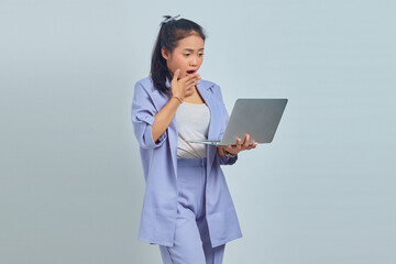 Portrait of surprised young Asian business woman looking at incoming email on laptop isolated on white background