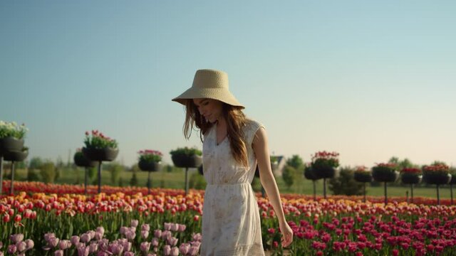 Beautiful lady walking in tulip garden. Woman spending time at flowers field.