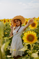 woman with pigtails in a hat on a field of sunflowers Summer time