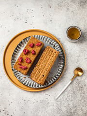 Honey cake on a plate. Pieces of cake on a light background.