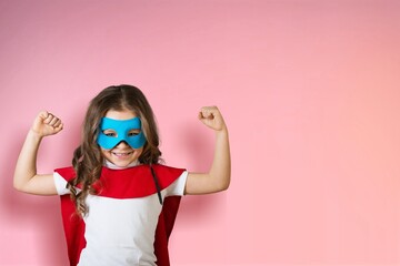 Portrait of little kid. Funny little power superhero kid showing muscles.