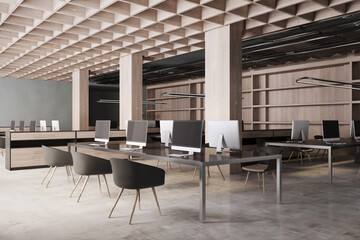 Concrete and wooden coworking office interior with empty computer screens, equipment, furniture and daylight. 3D Rendering.