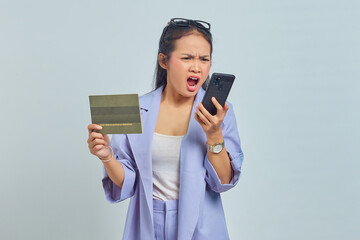Naklejka premium Portrait of angry young Asian woman yelling at mobile phone and showing vehicle book isolated on white background