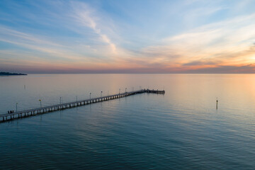 Fototapeta na wymiar Long wooden pier at sunset - aerial view