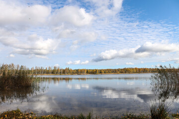 Cloudy Overcast autumn view with small river and cloudy sky.