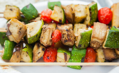 Vegetable skewer close-up. Fried on wooden sticks zucchini, cherry tomatoes, eggplant and bell peppers.