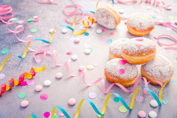 Traditional Berliner for carnival and party. German Krapfen or donuts with streamers and confetti. - obrazy, fototapety, plakaty