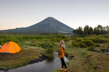 Muslim women camping by the river with Mount Semeru in the background