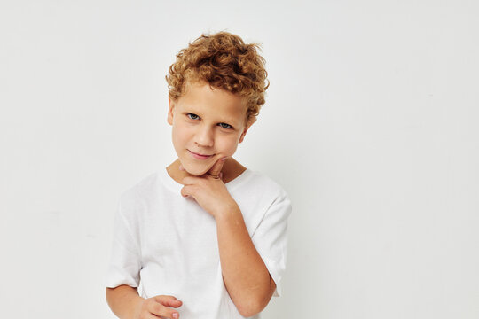 Photo of young boy in a white t-shirt posing fun childhood unaltered