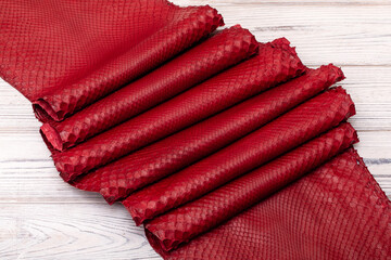 red dyed genuine natural python leather on the wooden table	
