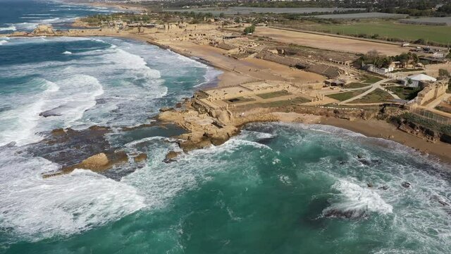 Tilting aerial view of ancient Caesarea city, spectacular shoreline in Northern Israel
