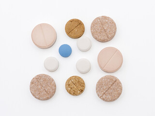 Medicines in colored pills. Isolated flat lay on white background.