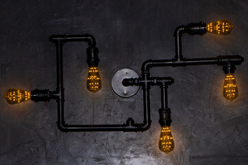 Antique Edison style decorative lamp against cement wall background.
