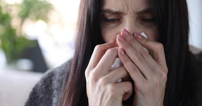 Woman dripping nasal spray into nose closeup