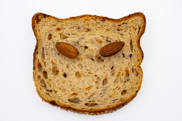 Funny animal face made from a slice of multigrain bread and almonds. Joyful healthy food. Isolated on white background.