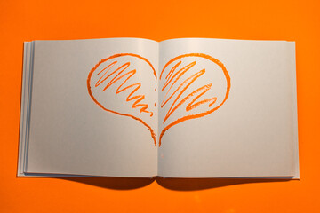 Drawn heart in a notebook on a yellow background. Happy Valentine's Day. High quality photo
