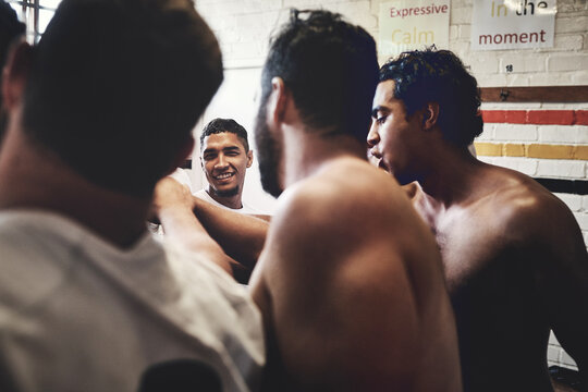 Team Spirit Is Everything. Cropped Shot Of A Group Of Handsome Young Rugby Players Standing Together In A Huddle In A Locker Room.