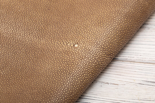natural colored brown sand rays leather on the wooden table	