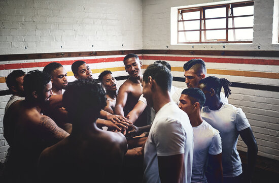 Gathering In The Spirit Of Winning. Cropped Shot Of A Group Of Handsome Young Rugby Players Standing Together In A Huddle In A Locker Room.