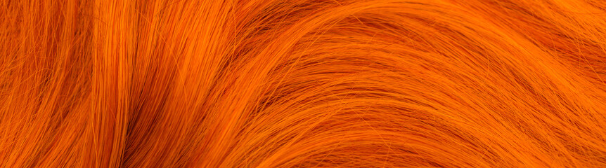 Red hair. Background hair closeup. Female long red-haired close-up as a background. Beautifully laid carroty wavy shiny curls. Hair coloring.Hairdressing procedures. Copy space with space for text.