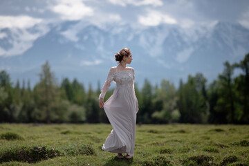 Naklejka na ściany i meble a girl in a royal image, a girl walks against the backdrop of mountains, a girl in a gray dress