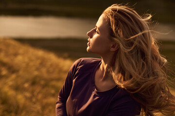 Serene woman in nature in sunset