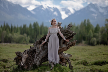 a girl in a royal image, a girl walks against the backdrop of mountains, a girl in a gray dress