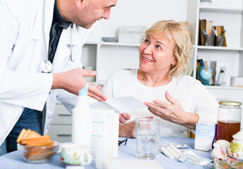 Obraz premium Doctor explains the mature woman how to take medicine for successful treatment