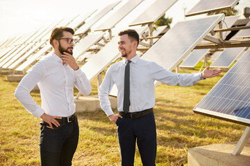 Businessmen in field with solar panels
