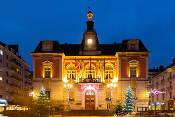 Scenic night view of Chambery town hall in central square during winter Christmas season with bright lighting and traditional decorations, France © JackF