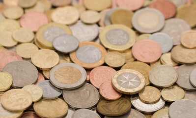 Different money coins. US dollars money and euro as a background on a flat lay. Savings and economy. Coins of different denominations from different countries. Inflation and exchange rates.