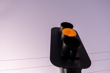 Looking up at orange traffic light against the sky at sunset with copy space - 481110514