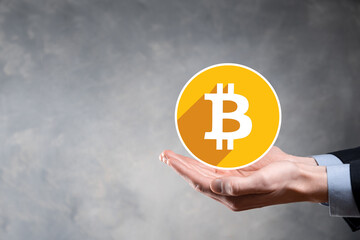 Male hand holding a bitcoin icon on grey background. Bitcoin Cryptocurrency Digital Bit Coin BTC Currency Technology Business Internet Concept