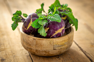 Purple kohlrabi cabbage on wooden background with copy space. Side view. Healthy vegetarian food