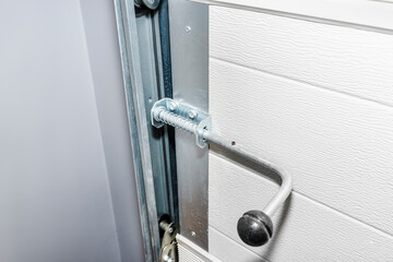 Manual spring latch from the home garage door, visible guides from the gate.