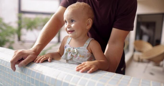 Adorable excited toddler and her father behind swimming pool edge