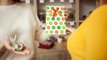 woman chooses gift in tea shop, beautiful festive package. seller offers goods. Private small business, entrepreneur.