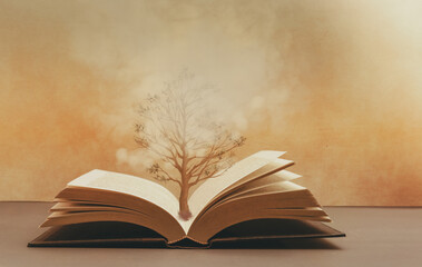 The tree of knowledge , a tree growing from the pages of an  open book , fantasy image concept of...